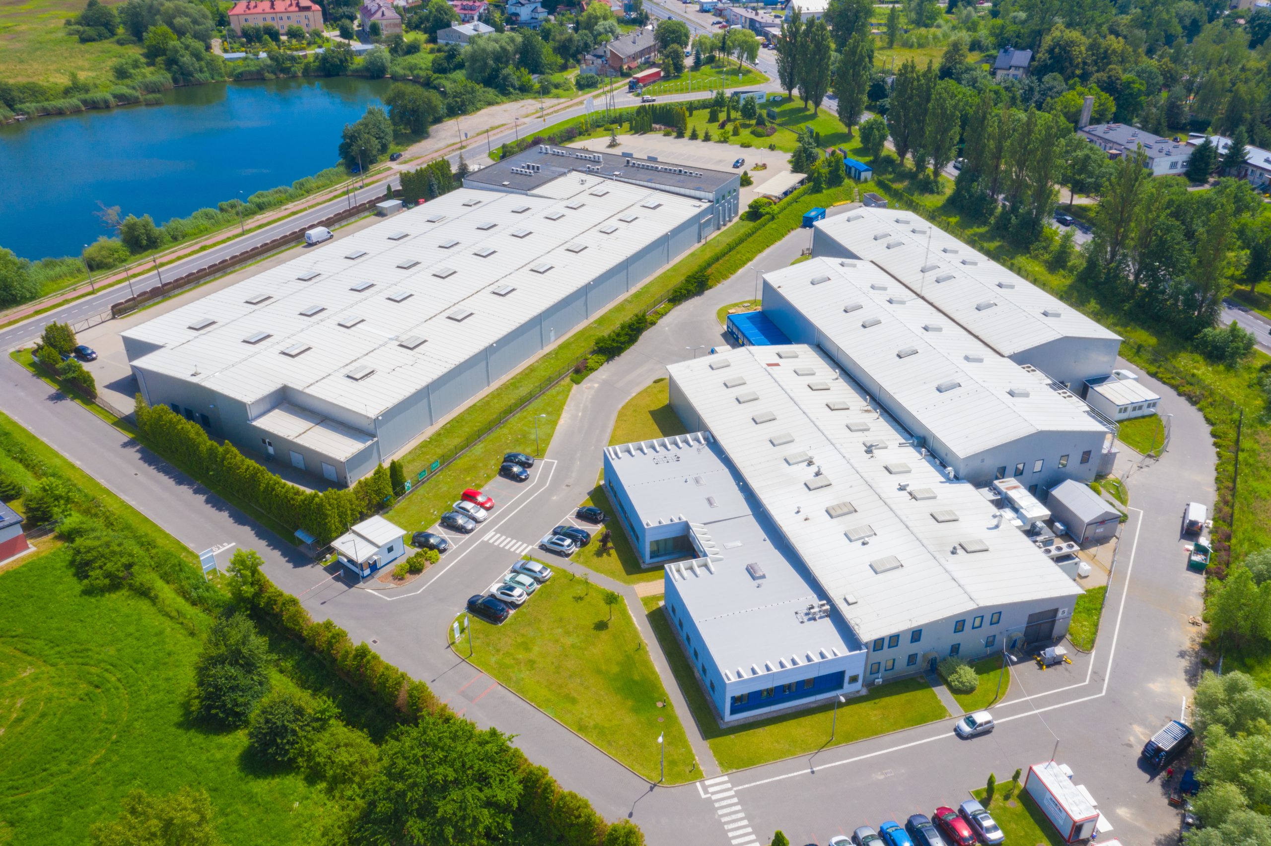 Aerial view of goods warehouse. Logistics center in industrial city zone from above. Aerial view of trucks loading at logistic center